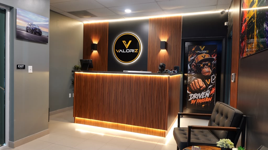Recepción del estudio Valoriz con logo iluminado y mostrador de madera.