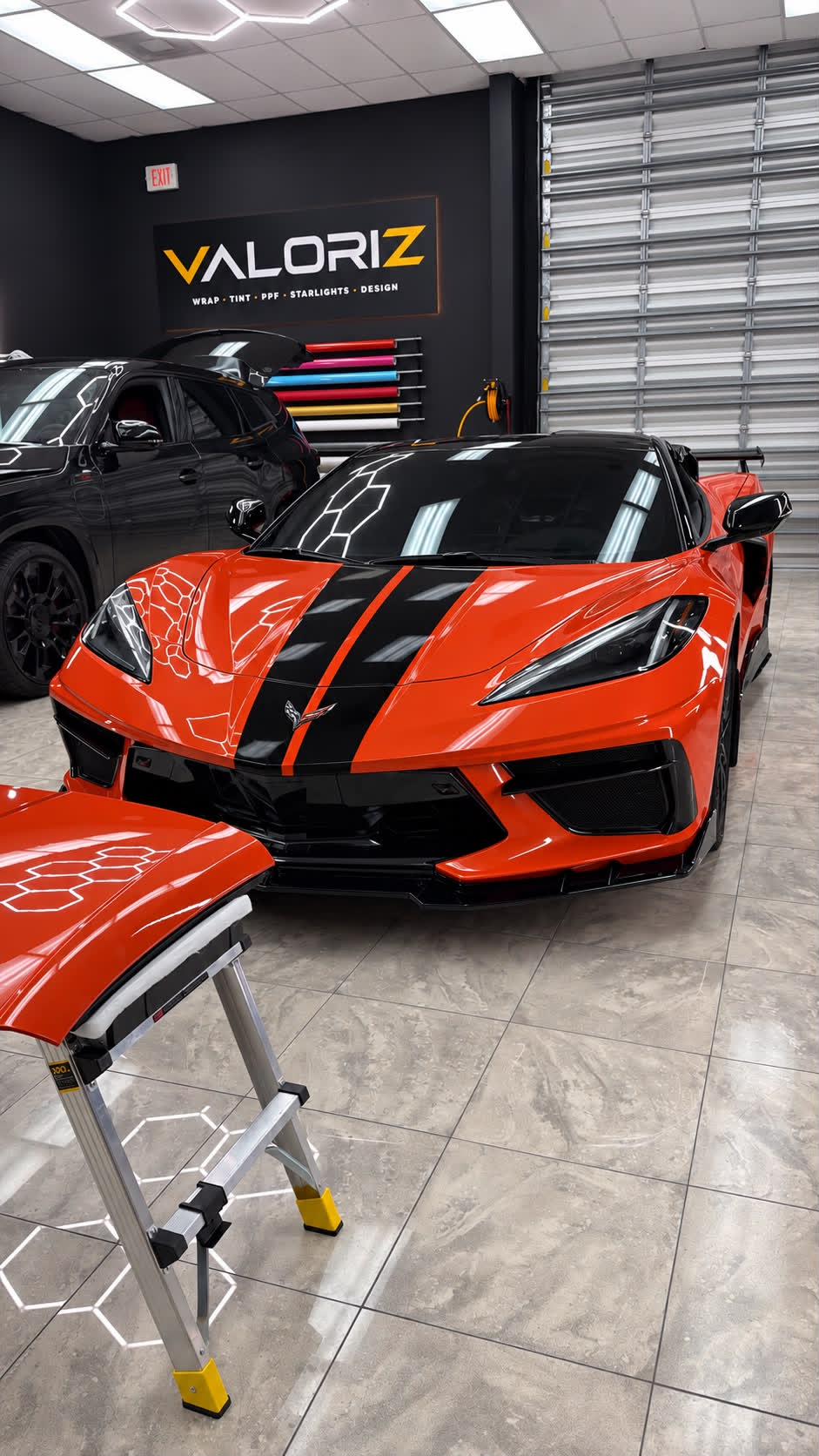 Corvette naranja con gráficos negros visto de frente.