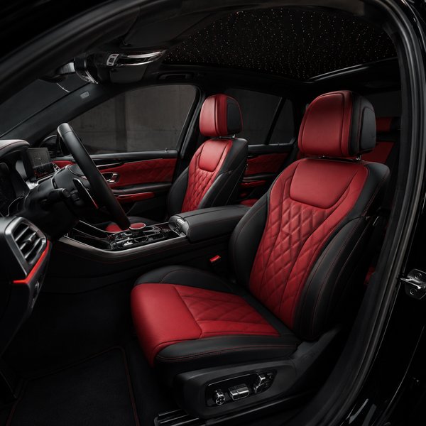Red leather seats and center console inside a car.